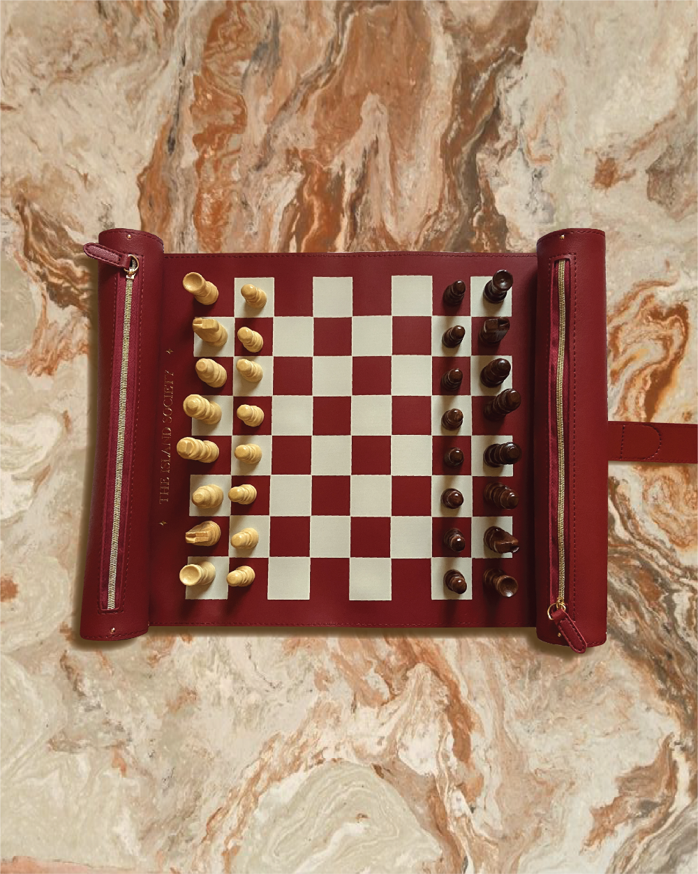 Burgundy vegan leather roll-up chess board with natural wooden chess pieces by The Island Society.