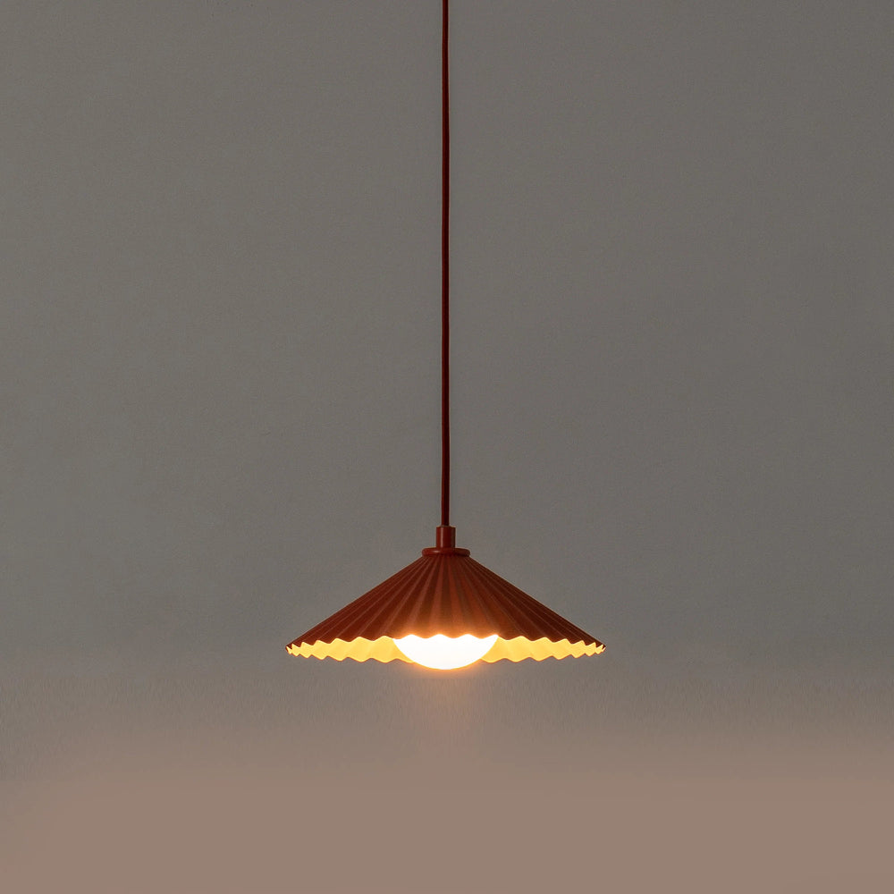 Pendant light with a wavy shade on a dark background