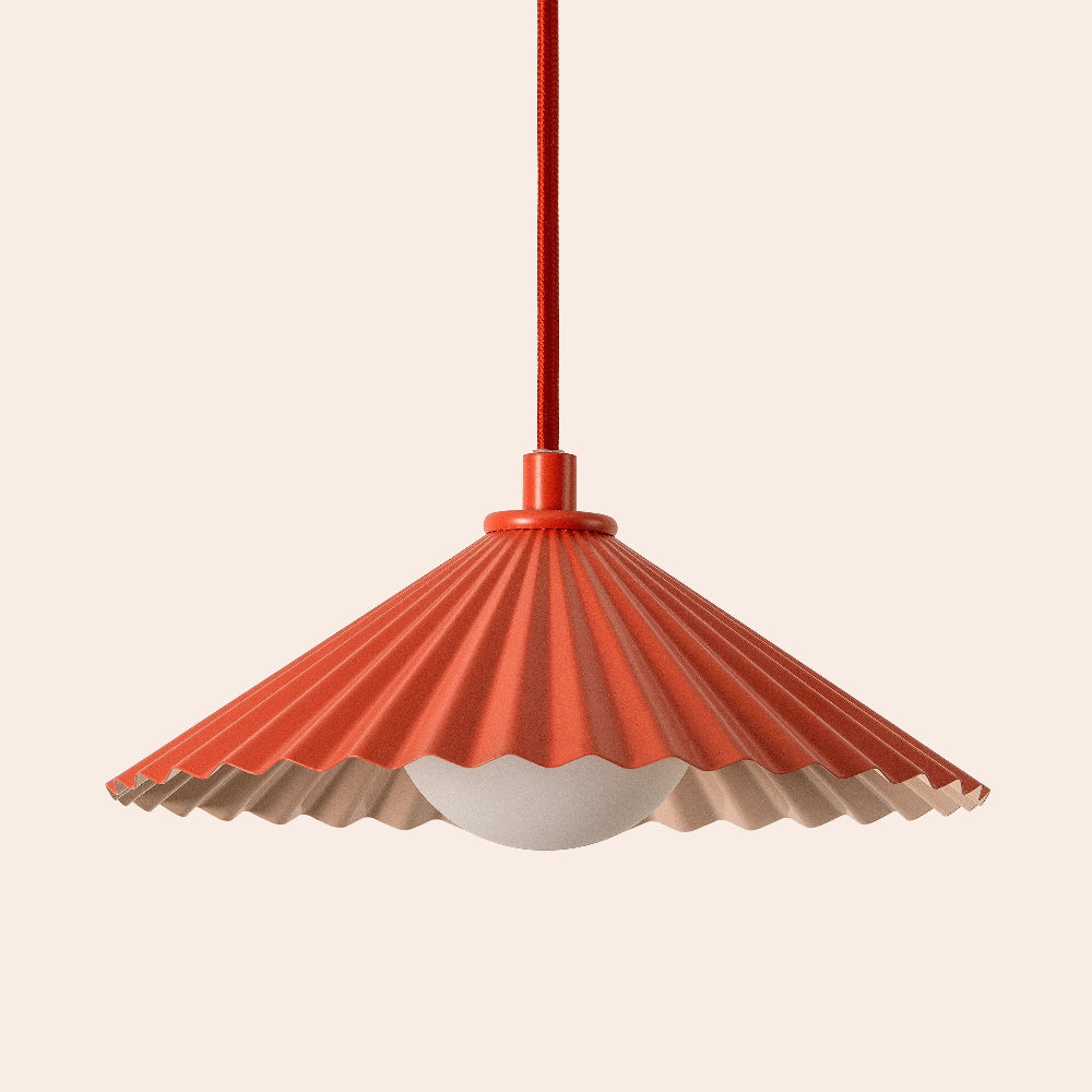 Orange pendant light with a scalloped edge on a beige background