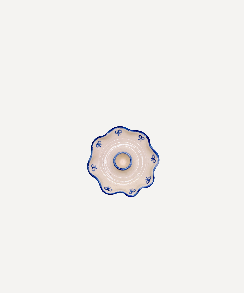 Decorative ceramic candle holder with blue floral patterns on a white background