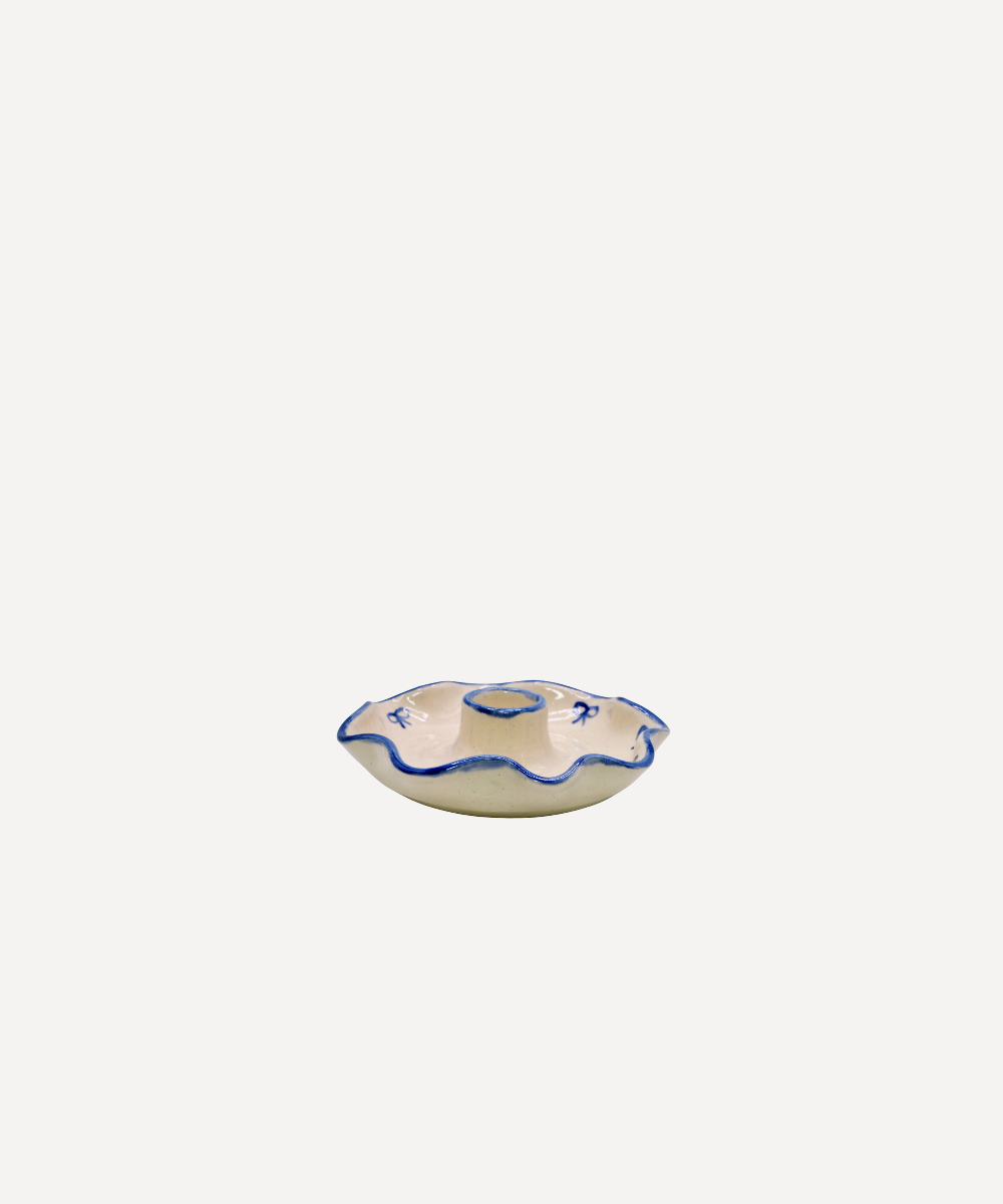 Ceramic candle holder with blue rim on a white background
