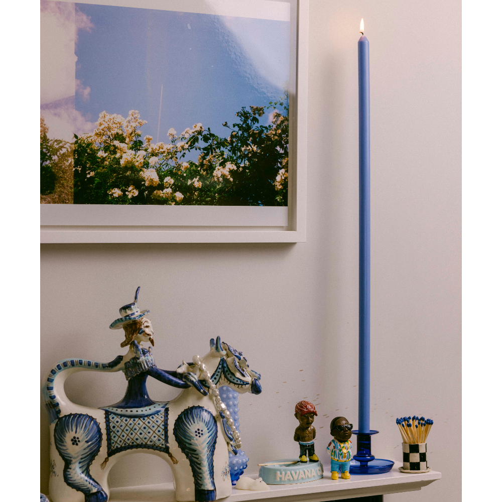 Decorative items including a ceramic figure of a woman on a horse, a blue candle, and small figurines on a shelf.