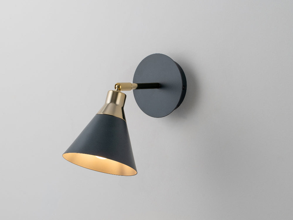 Side view of charcoal grey cone wall light with brass detail