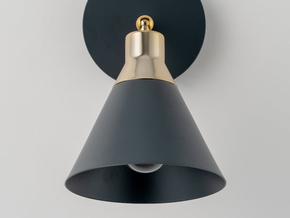 Close-up of charcoal grey wall light with solid brass cap