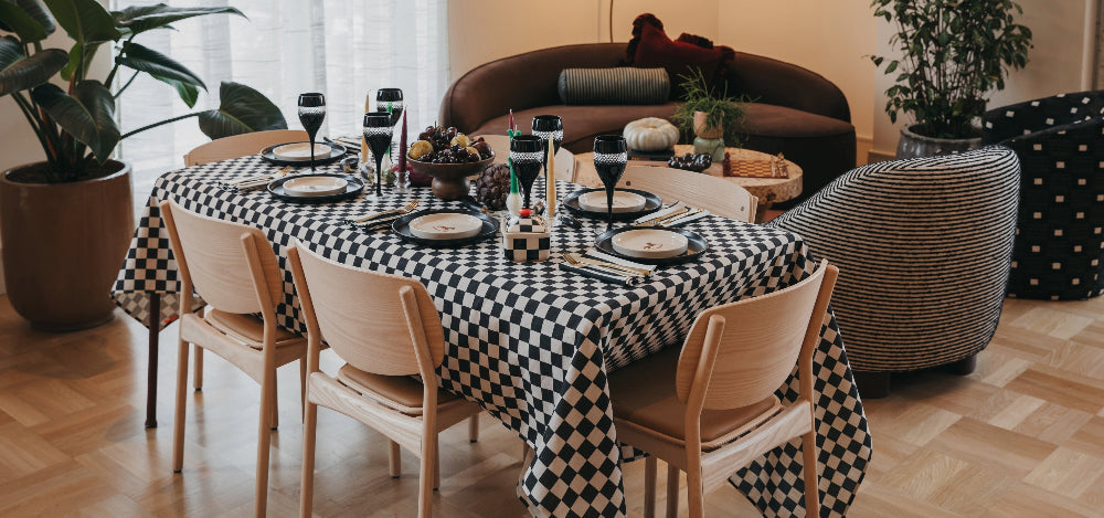 Black and white checkerboard tablecloth styled for a festive dining table setting