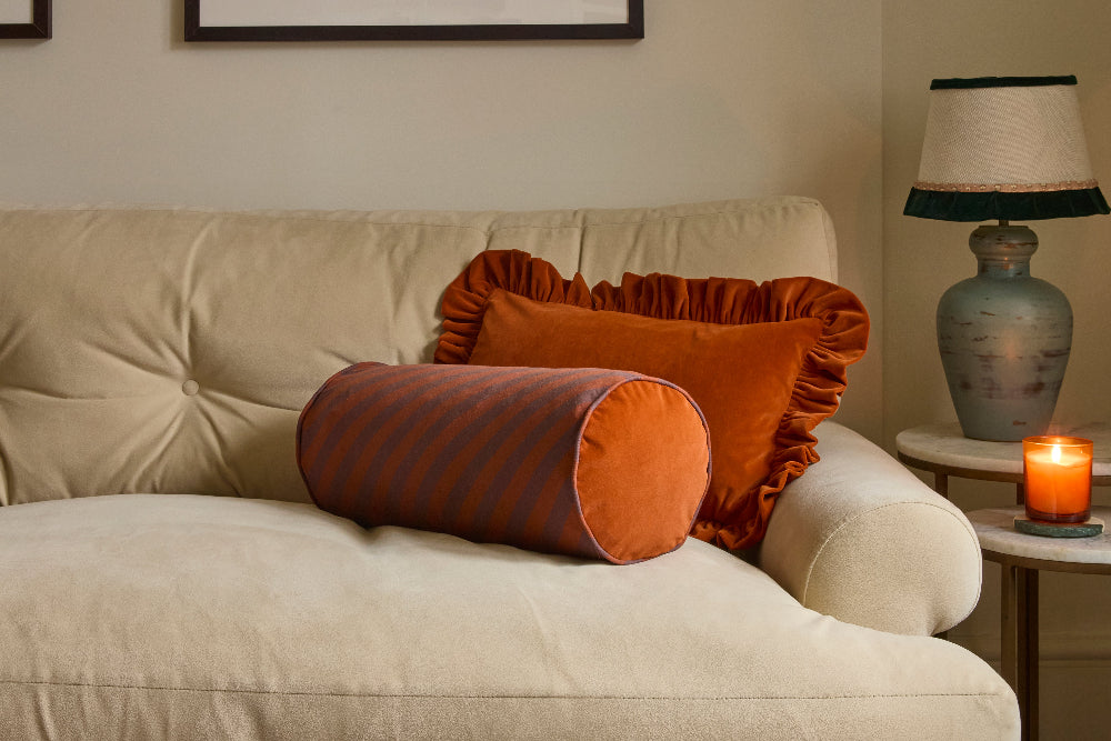 Chocolate and rust cotton linen bolster cushion showing the striped fabric and piping
