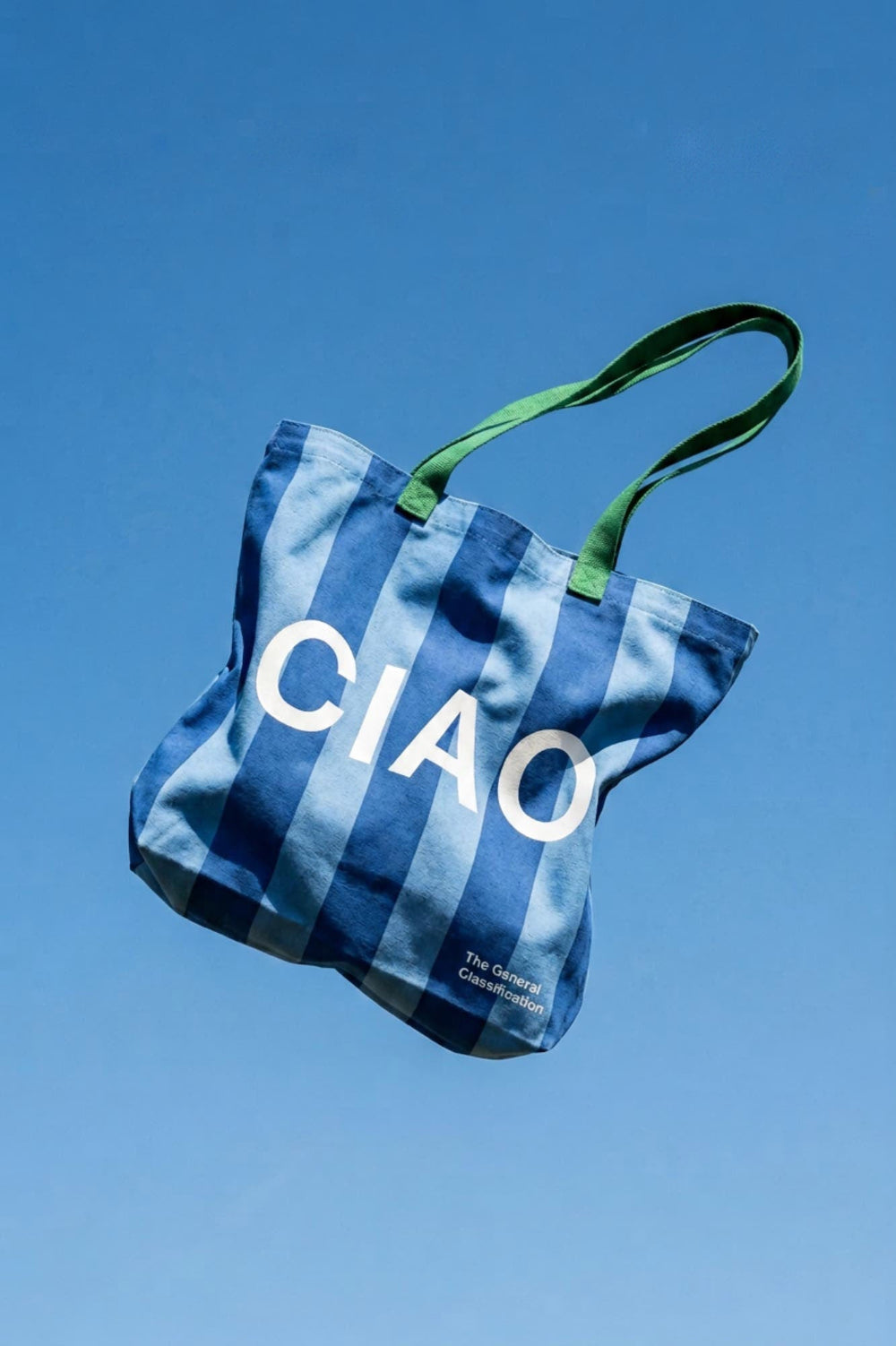 Blue striped bag with 'CIAO' text against a clear blue sky