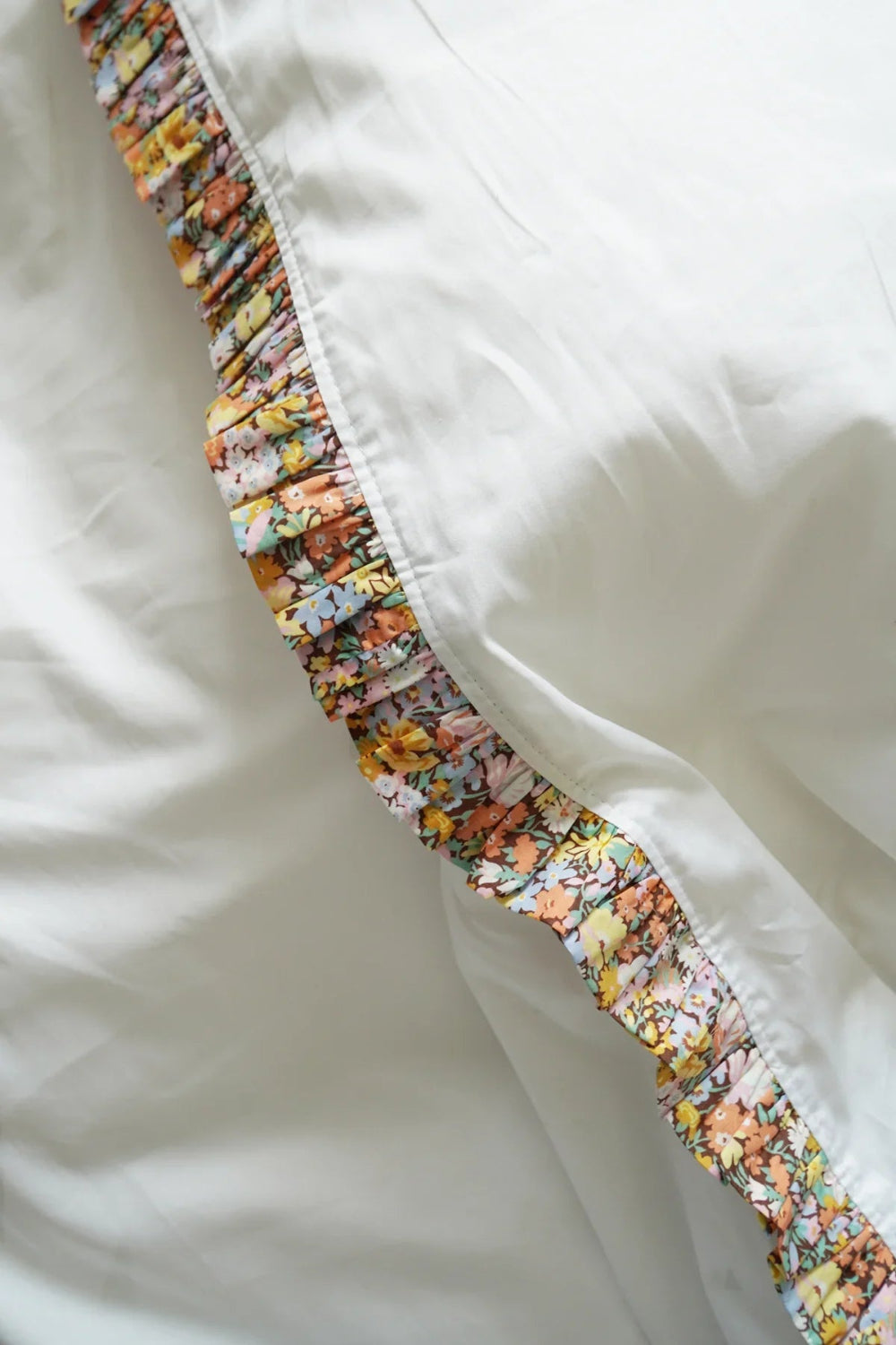 Floral-patterned trim on a white duvet ser
