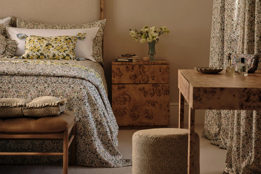Cozy bedroom with floral bedding, wooden furniture, and decorative elements.