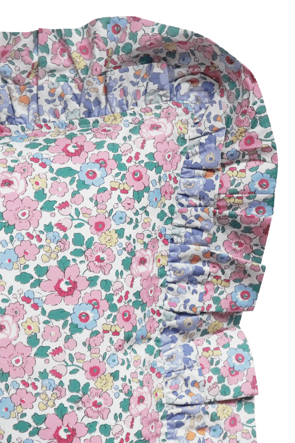 Floral patterned cushion with ruffled edge on a grey background closeup