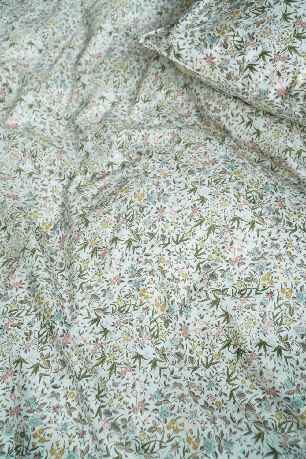 Liberty Floral patterned fabric with small flowers and leaves on a light background