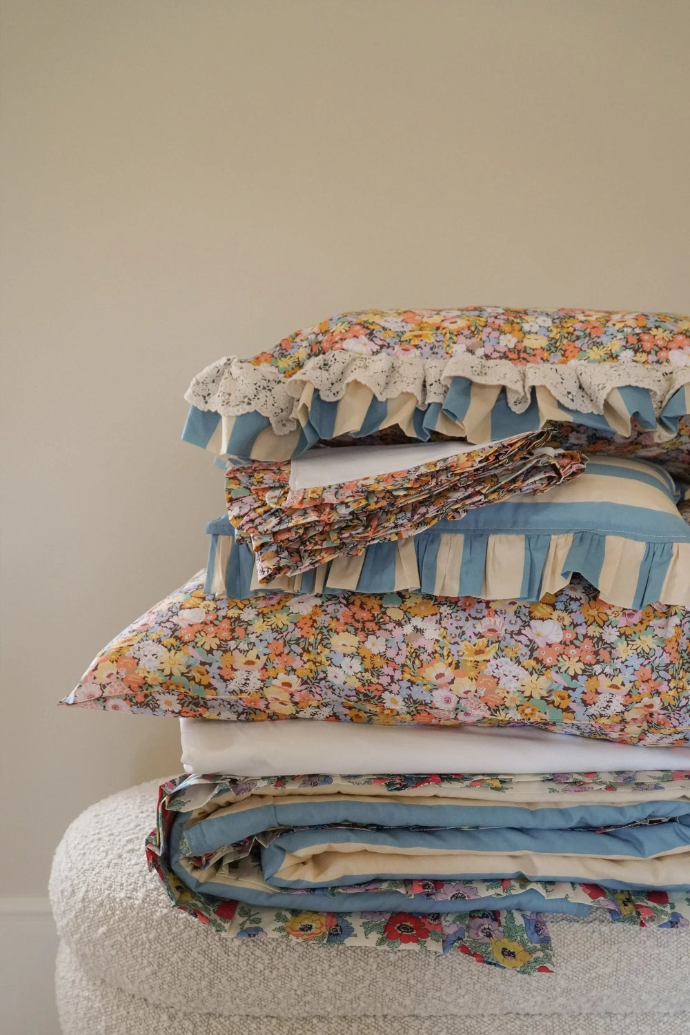 Stack of floral and striped fabric pieces on a neutral background