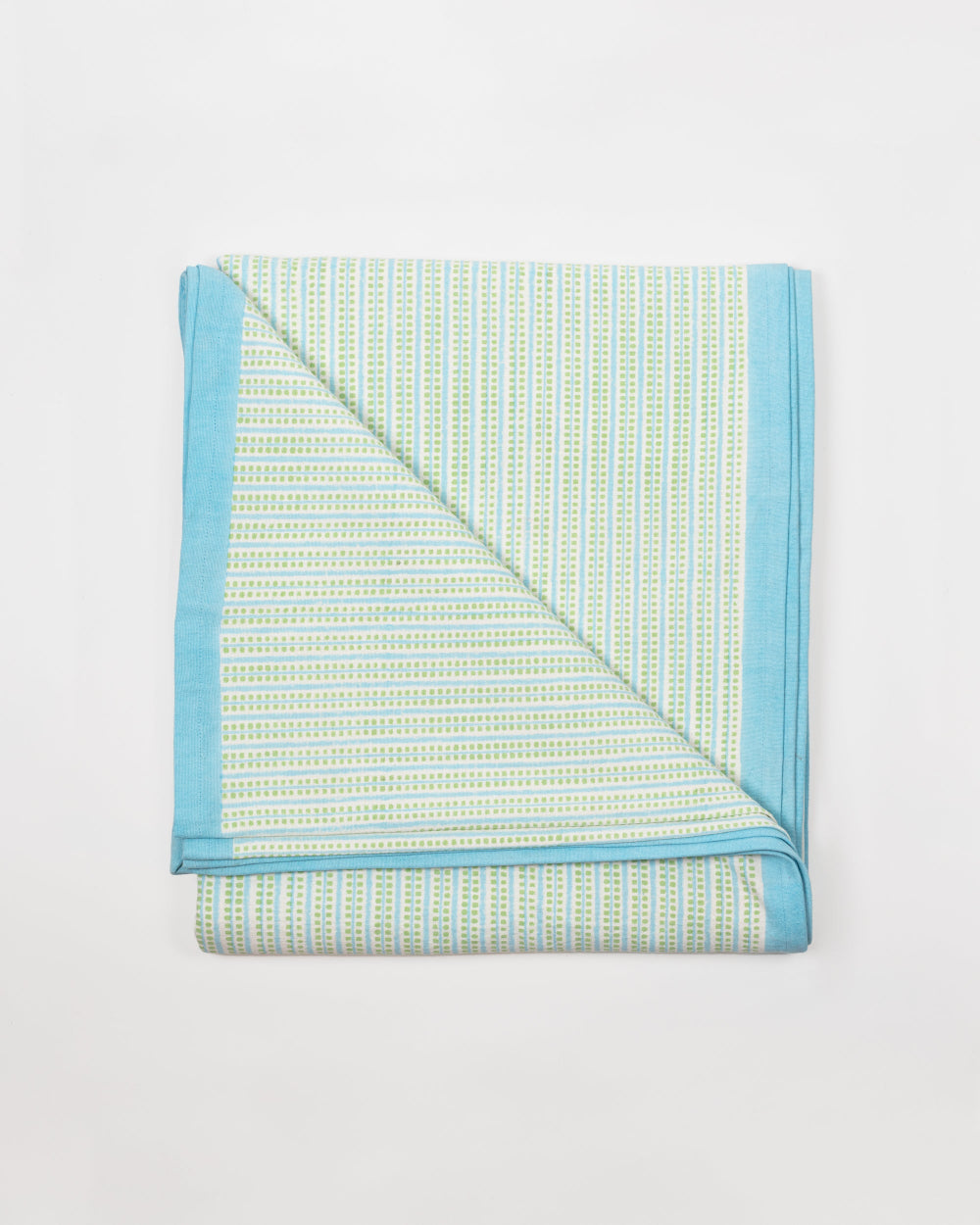 Folded tablecloth with blue border on a light grey background