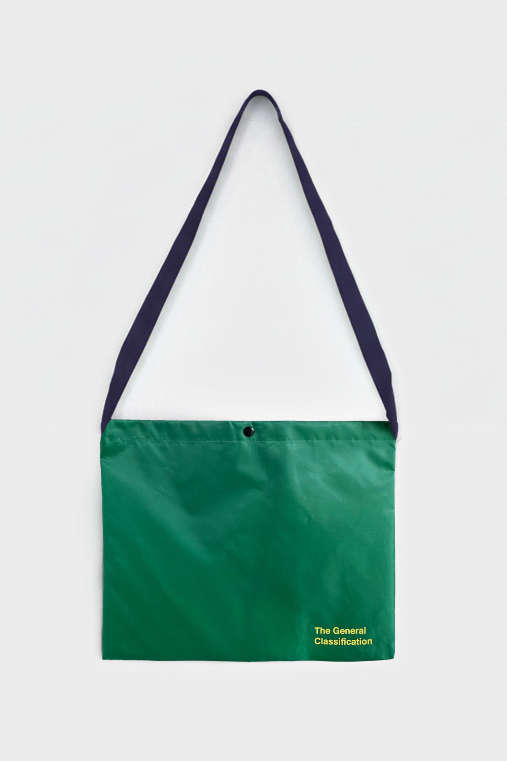 Green bag with a black strap on a light grey background
