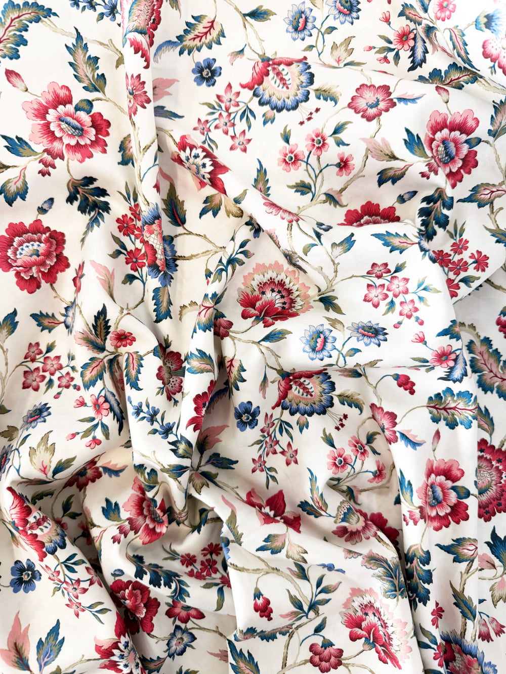 Floral fabric with red, blue, and pink flowers on a white background