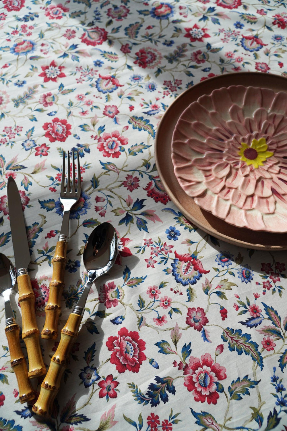Floral tablecloth with cutlery and a decorative plate
