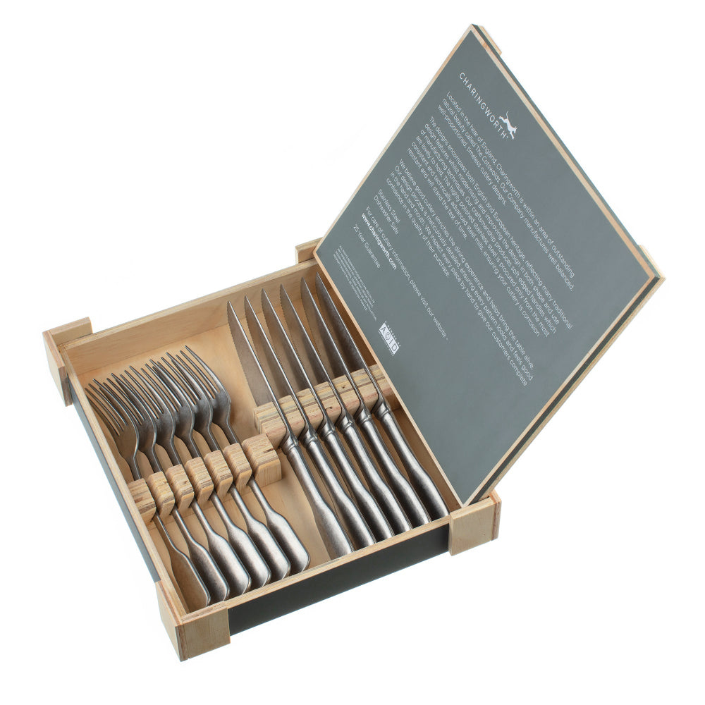 Set of silver cutlery in a wooden box with a grey lid on a white background