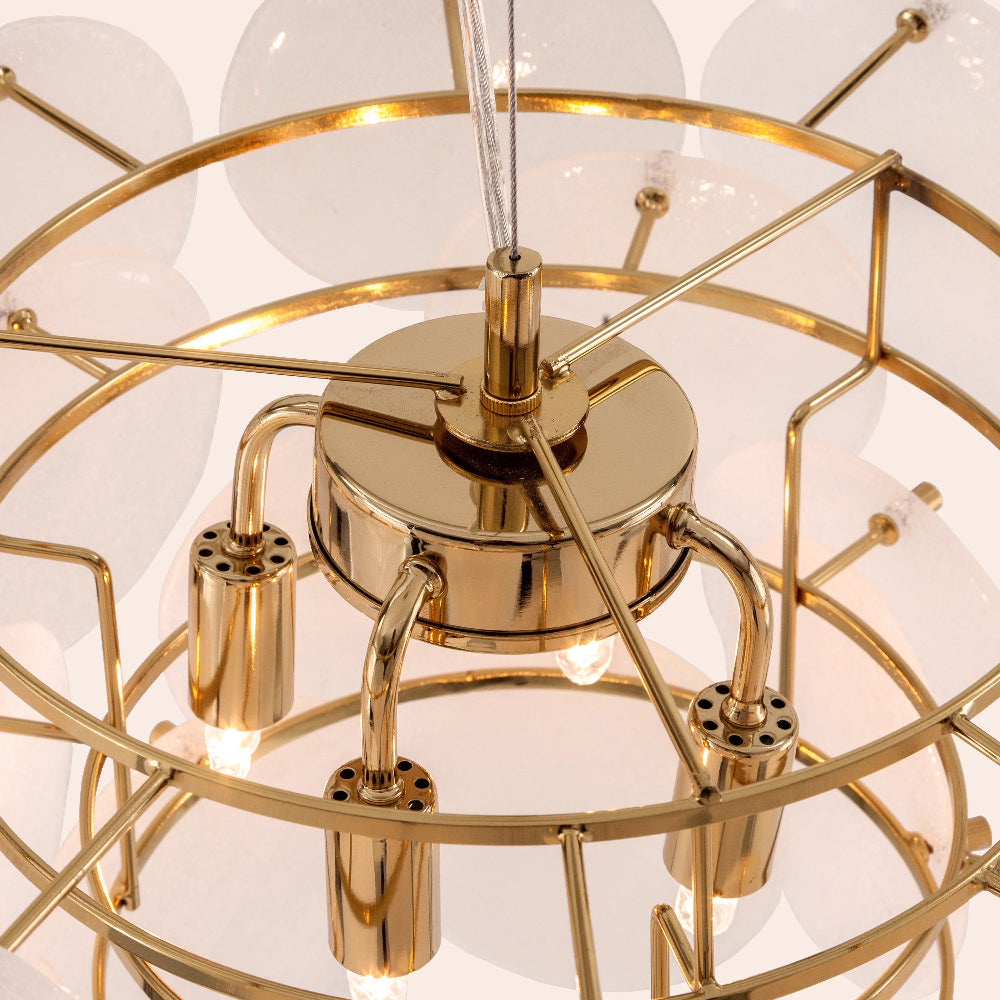 Gold chandelier with white glass disks on a light background