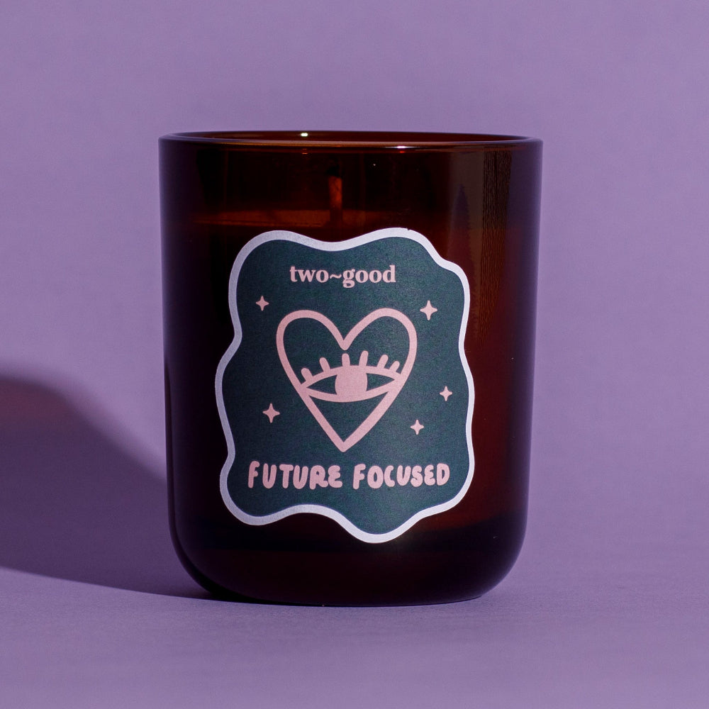 Brown candle jar with 'two-good' and 'Future Focused' label on a purple background