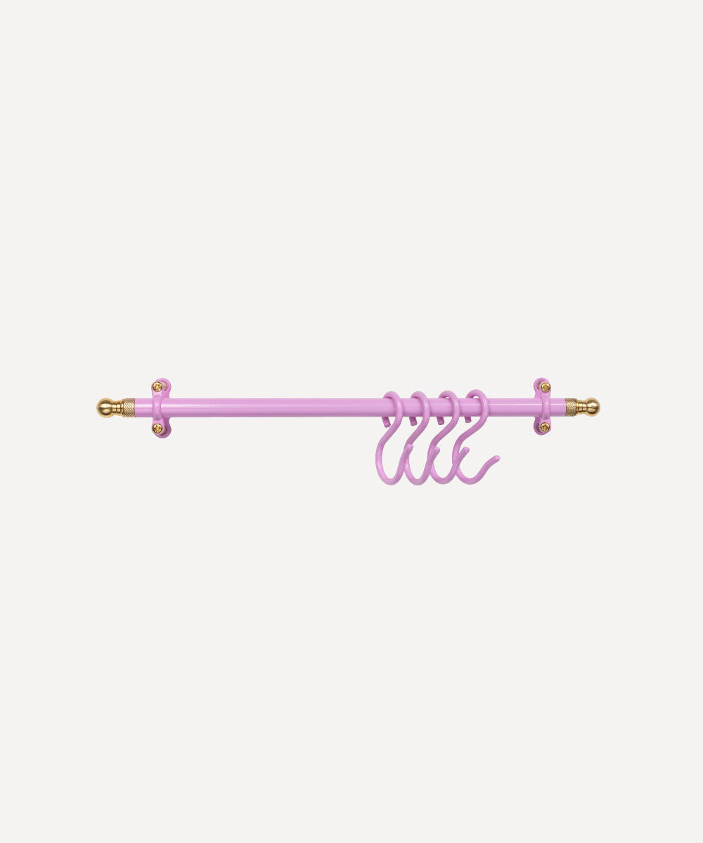 A light pink kitchen rail with decorative gold-toned finials and matching pink hanging hooks, shown against a plain light grey background.