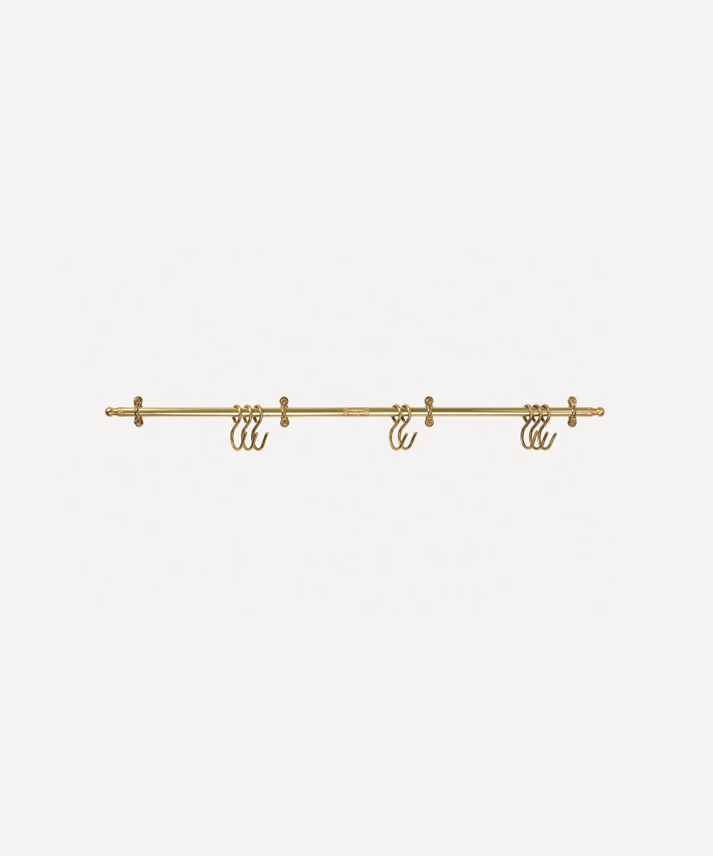 A gold metal wall-mounted rod with three hanging hooks, shown against a plain light grey background.