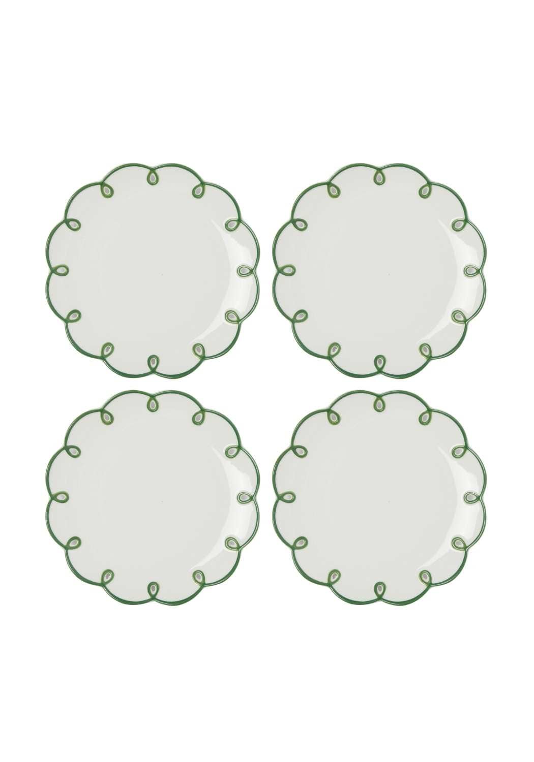 Four white plates with green decorative scalloped edges on a white background