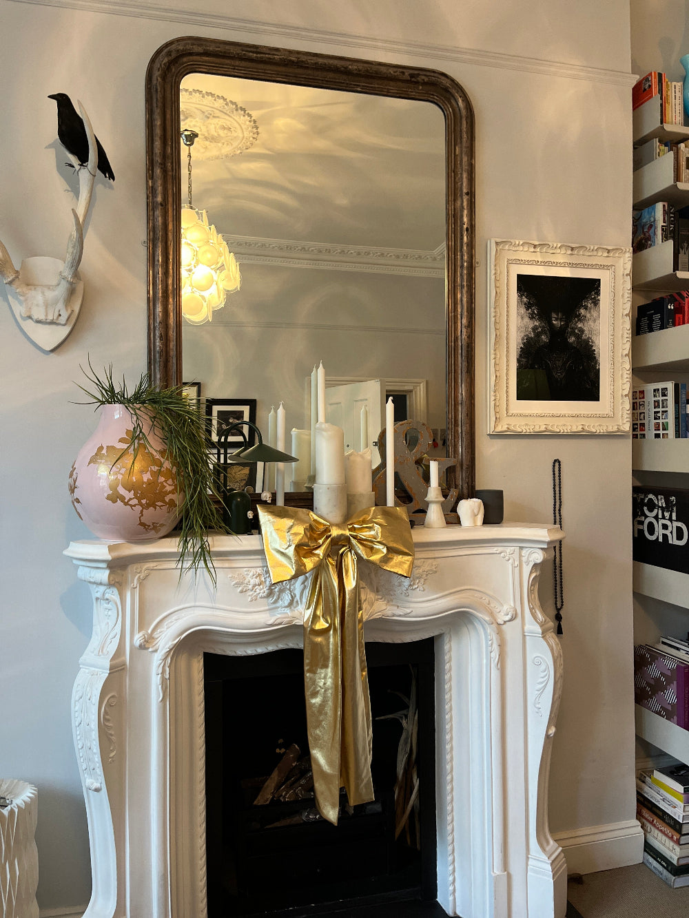 Oversized gold Christmas bow used as a statement fireplace mantel decoration