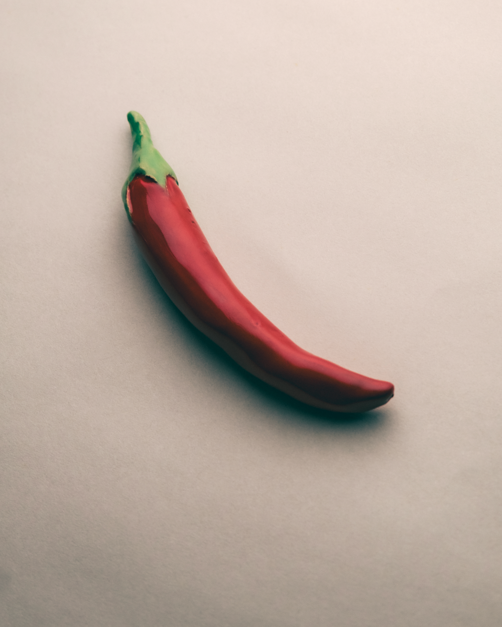 Ceramic red chilli pepper on a beige background