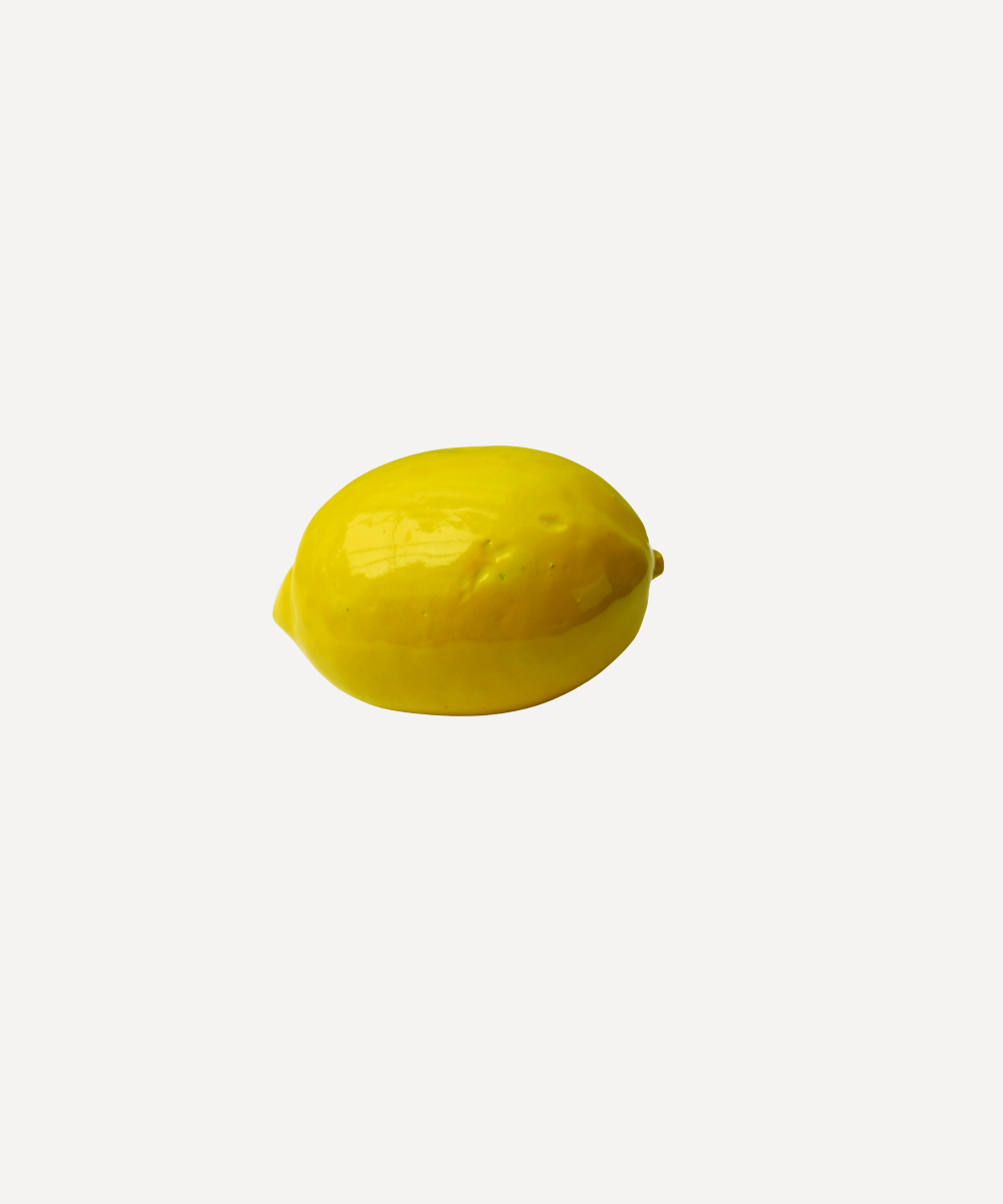 Yellow handmade ceramic lemon on a white background