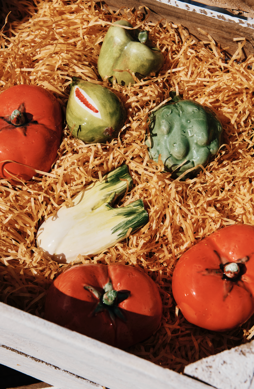 Decorative fruits and vegetables on straw in a wooden box