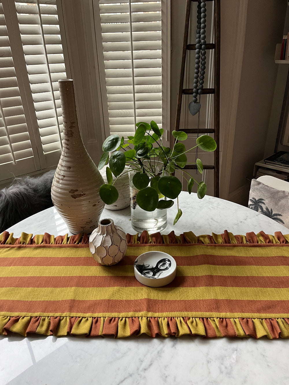 Handmade ruffled table runner styled as part of a colourful round table tablescape