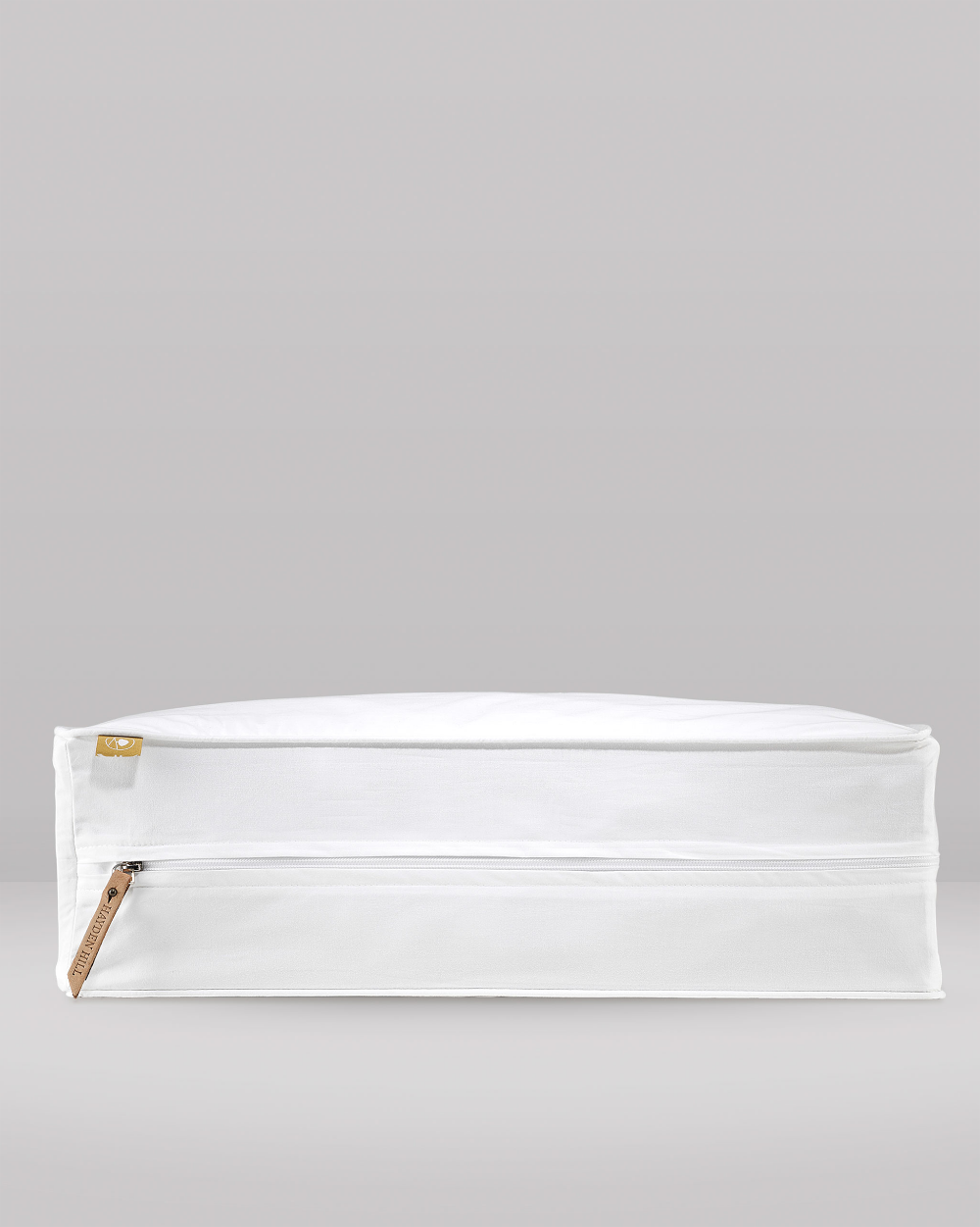 White storage box with a leather brown zipper on a grey background