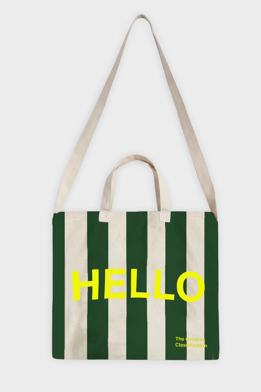 A canvas tote bag with vertical dark green and cream stripes, featuring the word 'HELLO' printed in bold yellow across the front. The bag has cream-coloured shoulder straps and handles, and small yellow text in the bottom right corner reading 'The General Classification'.