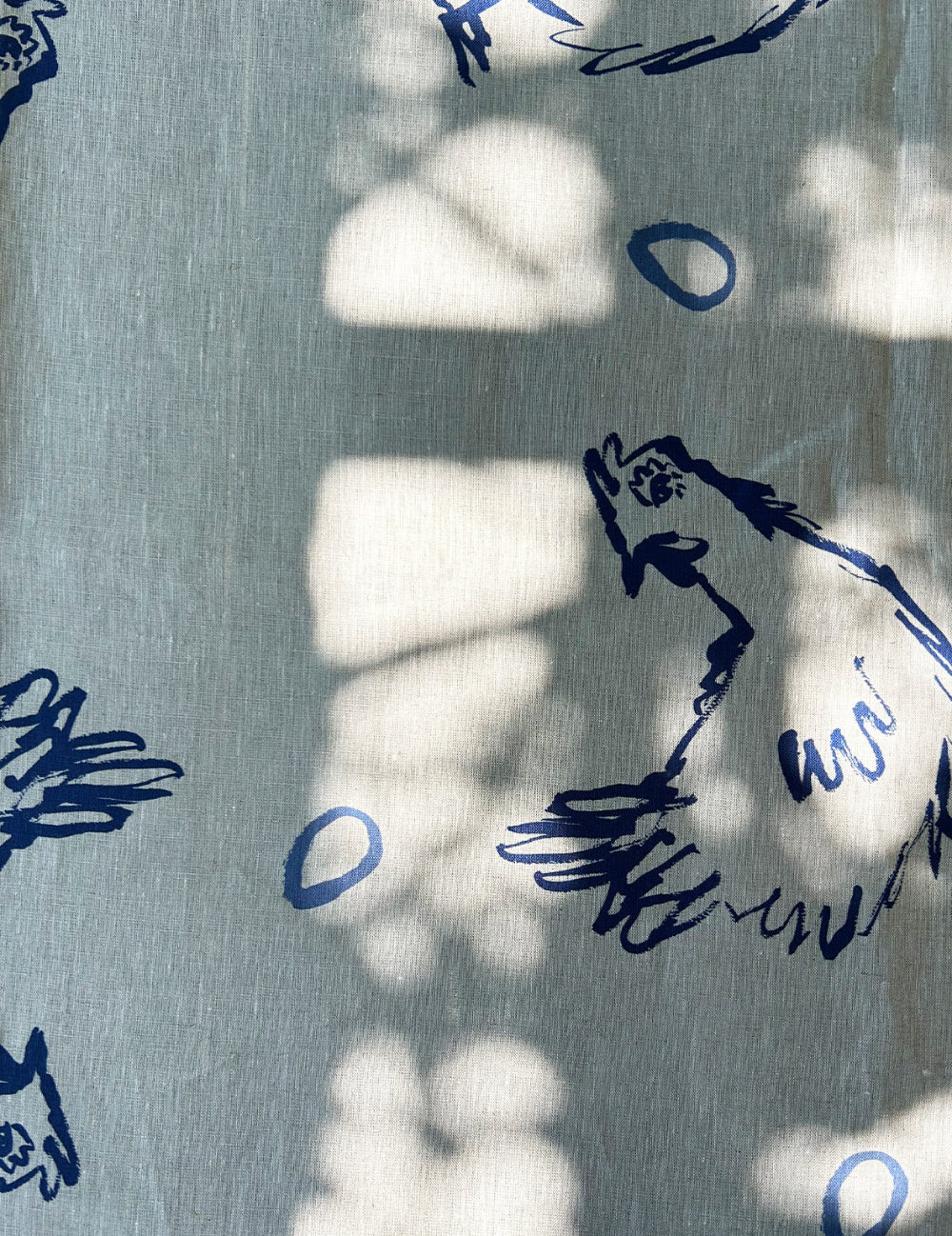 Blue hen illustrations on linen tablecloth on a table