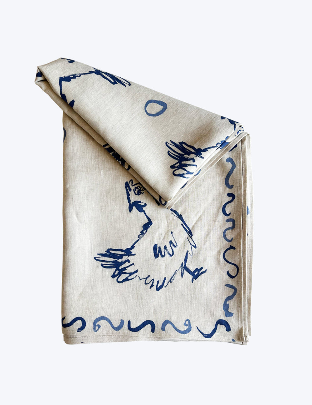 Folded Linen tablecloth with blue abstract patterns hens and chickens on a white background