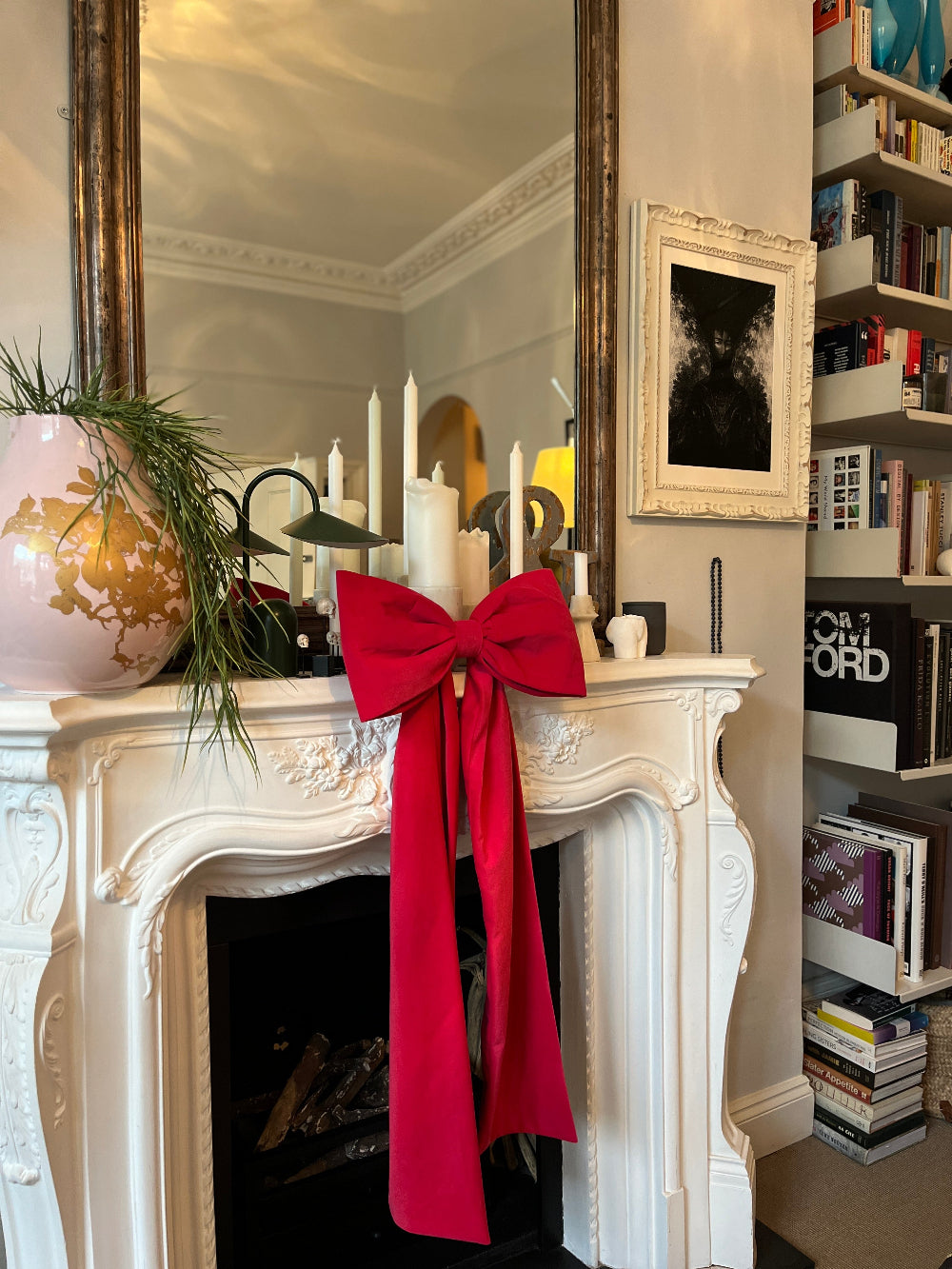 Hot pink velvet Christmas bow used as a statement fireplace mantel decoration