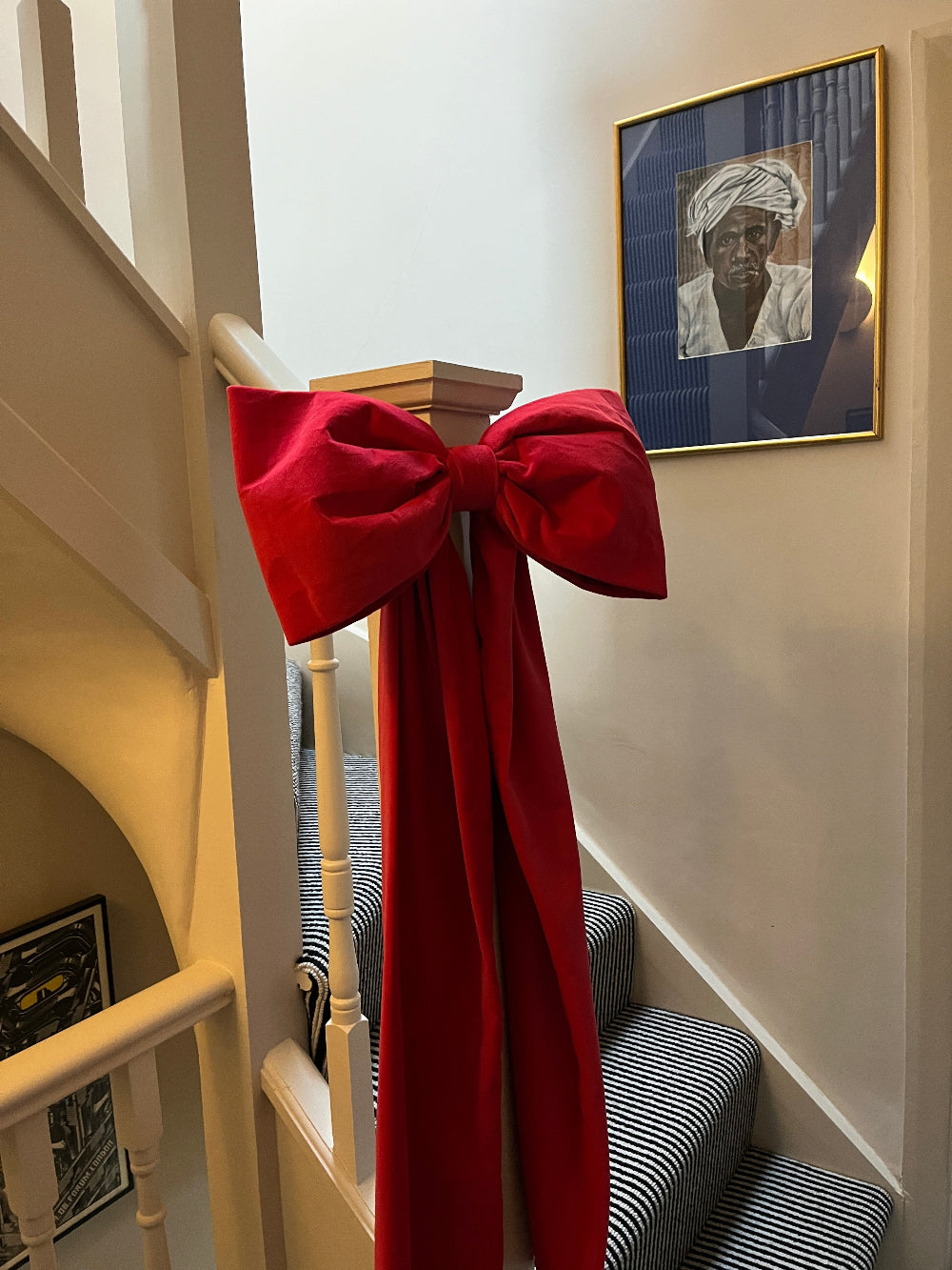 Hot pink velvet Christmas bow styled on a staircase bannister