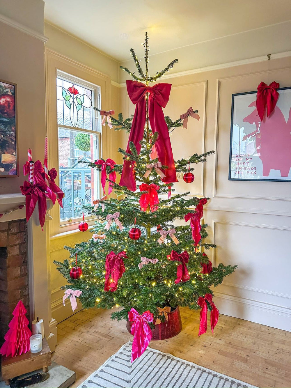Oversized hot pink velvet bow styled as a Christmas tree topper