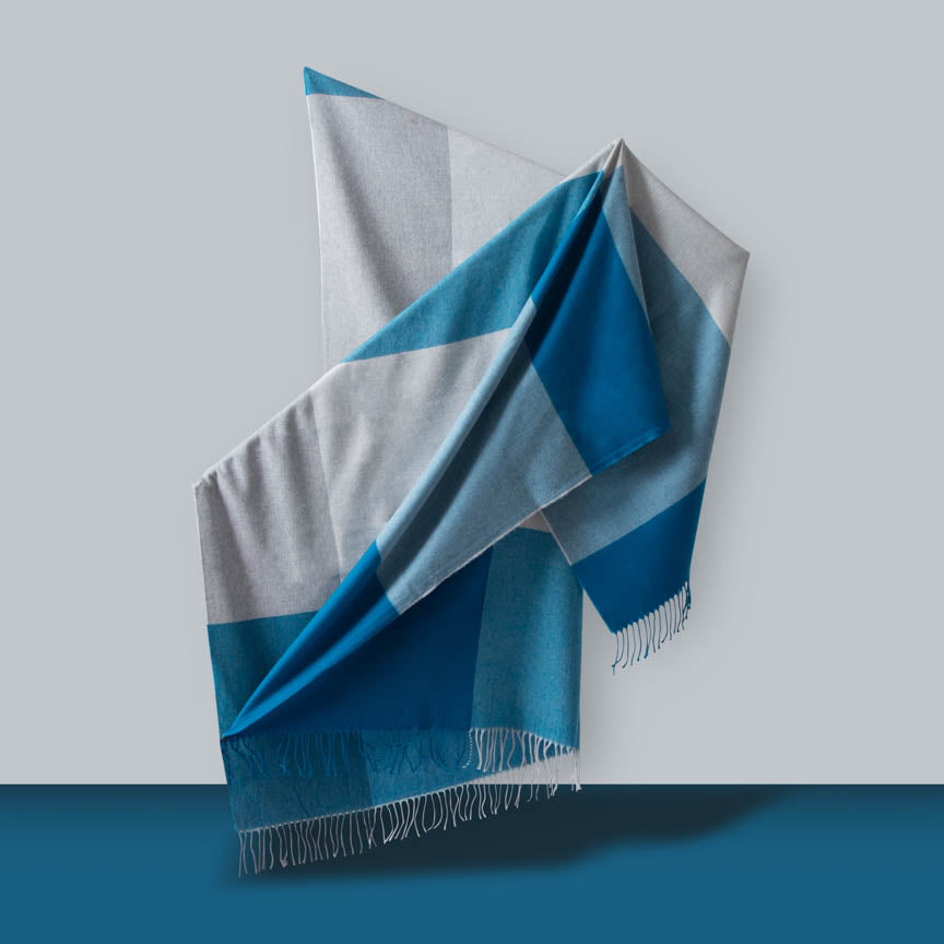 Blue and grey striped blanket on a light grey background