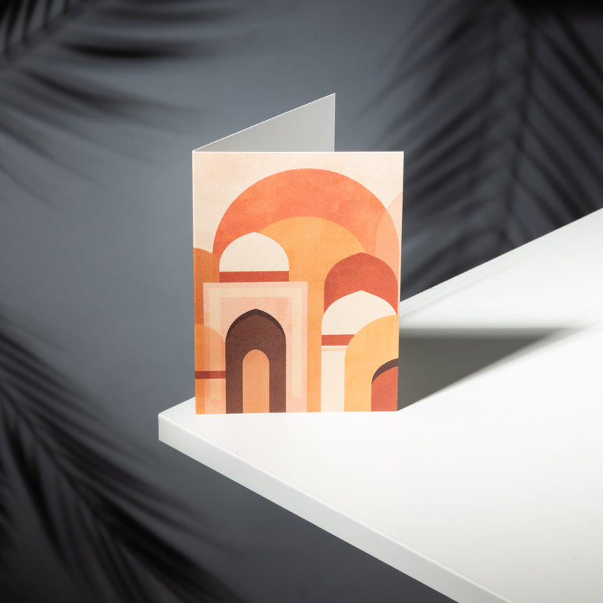 Geometric card with arches on a white surface against a dark background