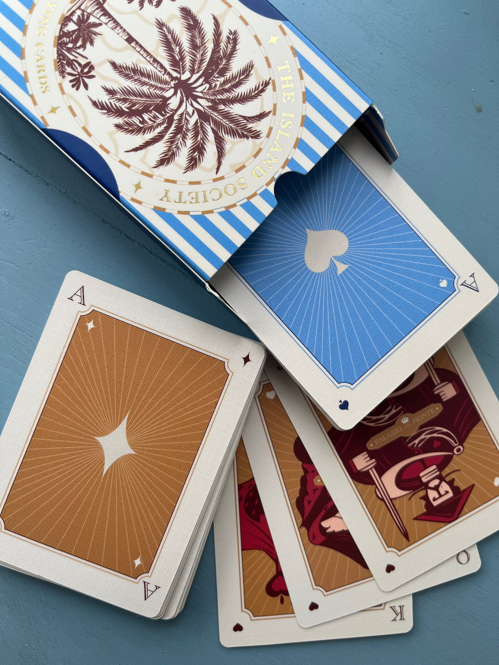 The Island Society's blue playing card design inspired by vintage European cards.