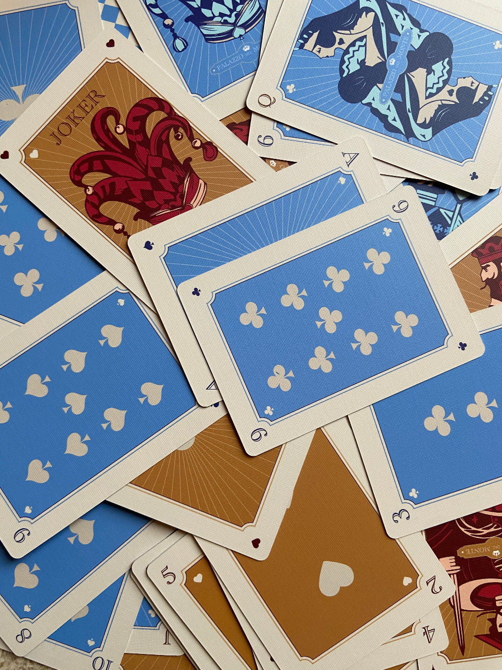 Detailed artwork on The Island Society playing cards, designed in Wales with distinctive illustrated faces and patterned backs.