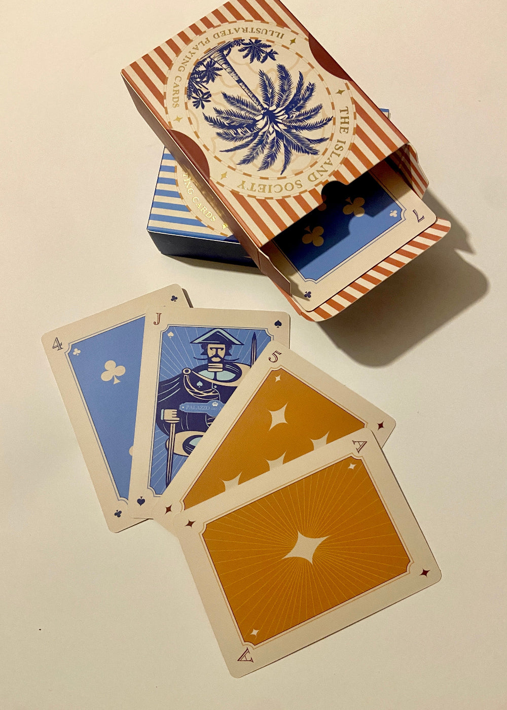 Two decks of illustrated playing cards by The Island Society, ideal for Canasta and traditional card games.