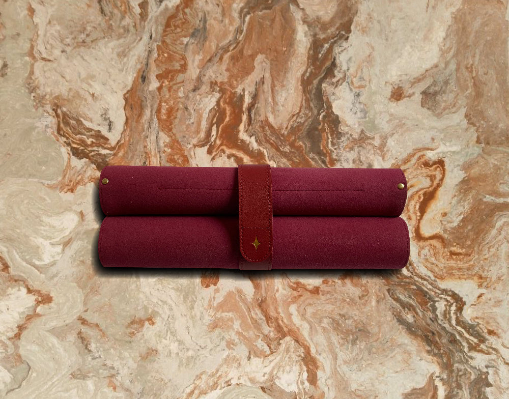 The Island Society portable travel chess set rolled up in its burgundy vegan leather case.