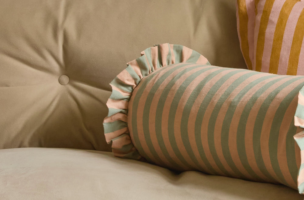 Jade and sand cotton linen bolster cushion with a soft ruffled finish