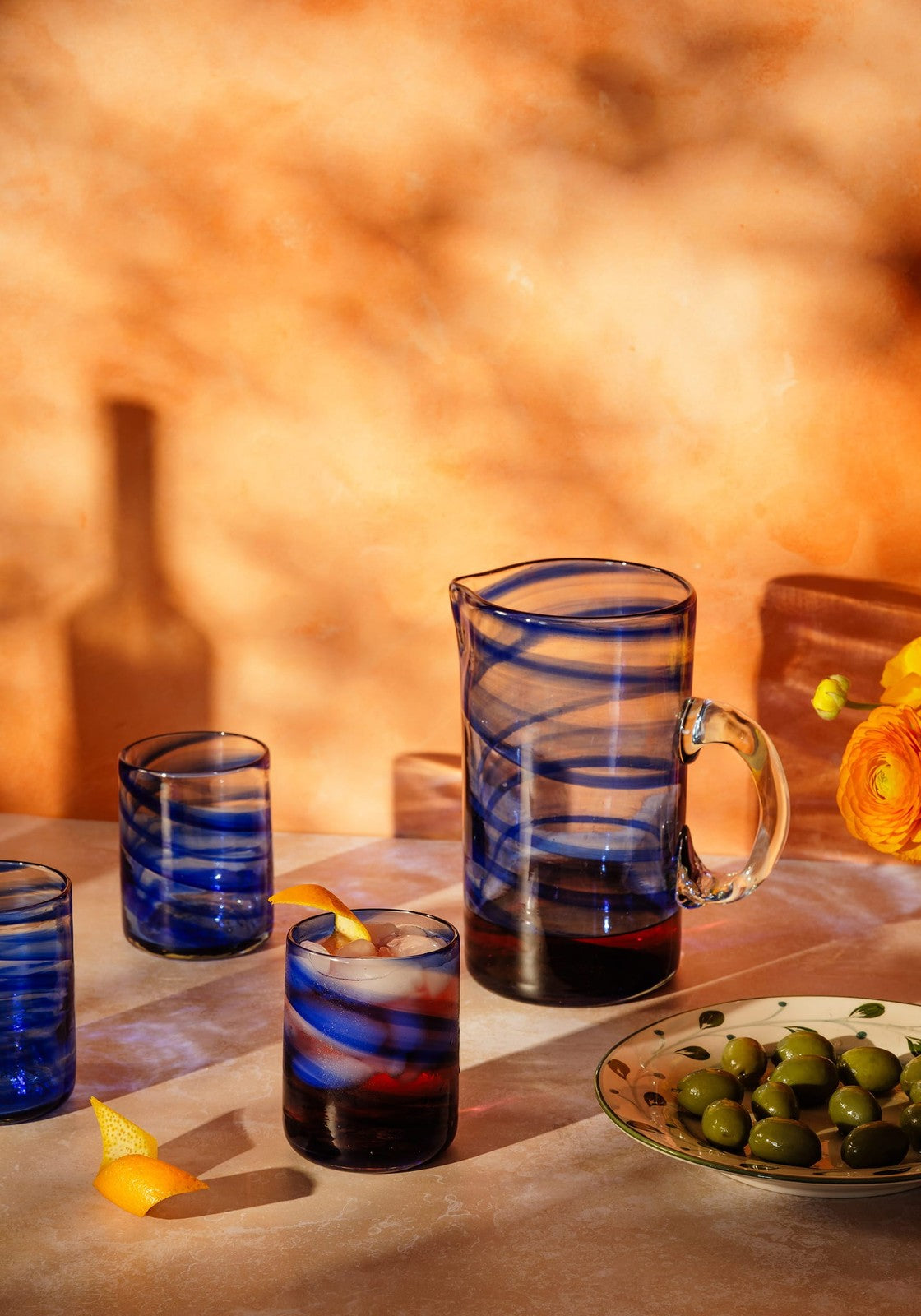 Set of blue glassware handblown in Mallorca on a table with a warm background