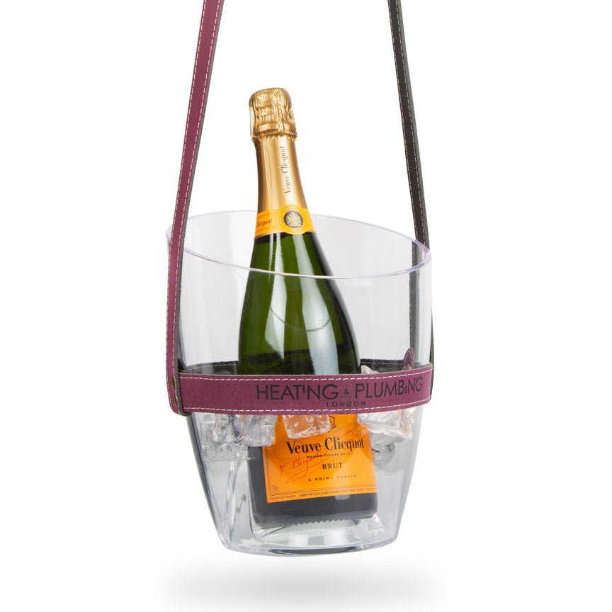 Bottle of Veuve Clicquot champagne in a clear ice bucket with a purple handle on a white background
