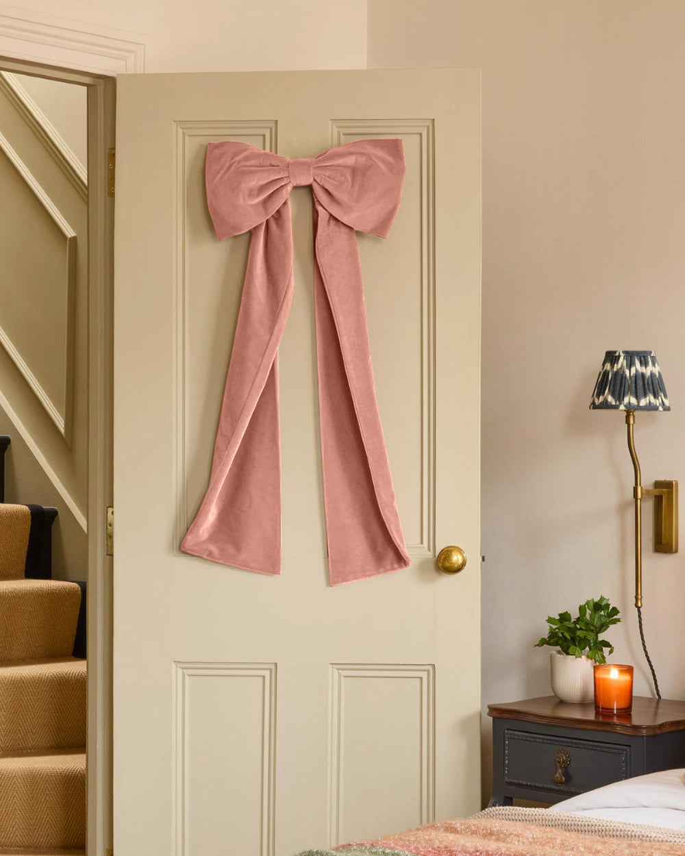 Kika Bespoke oversized coral velvet bow displayed on an indoor door