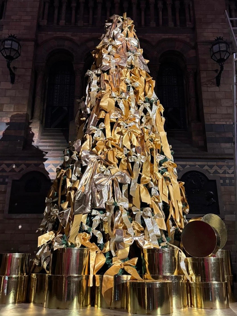 Kika Bespoke oversized gold bows decorating the Christmas tree at the Natural History Museum in London