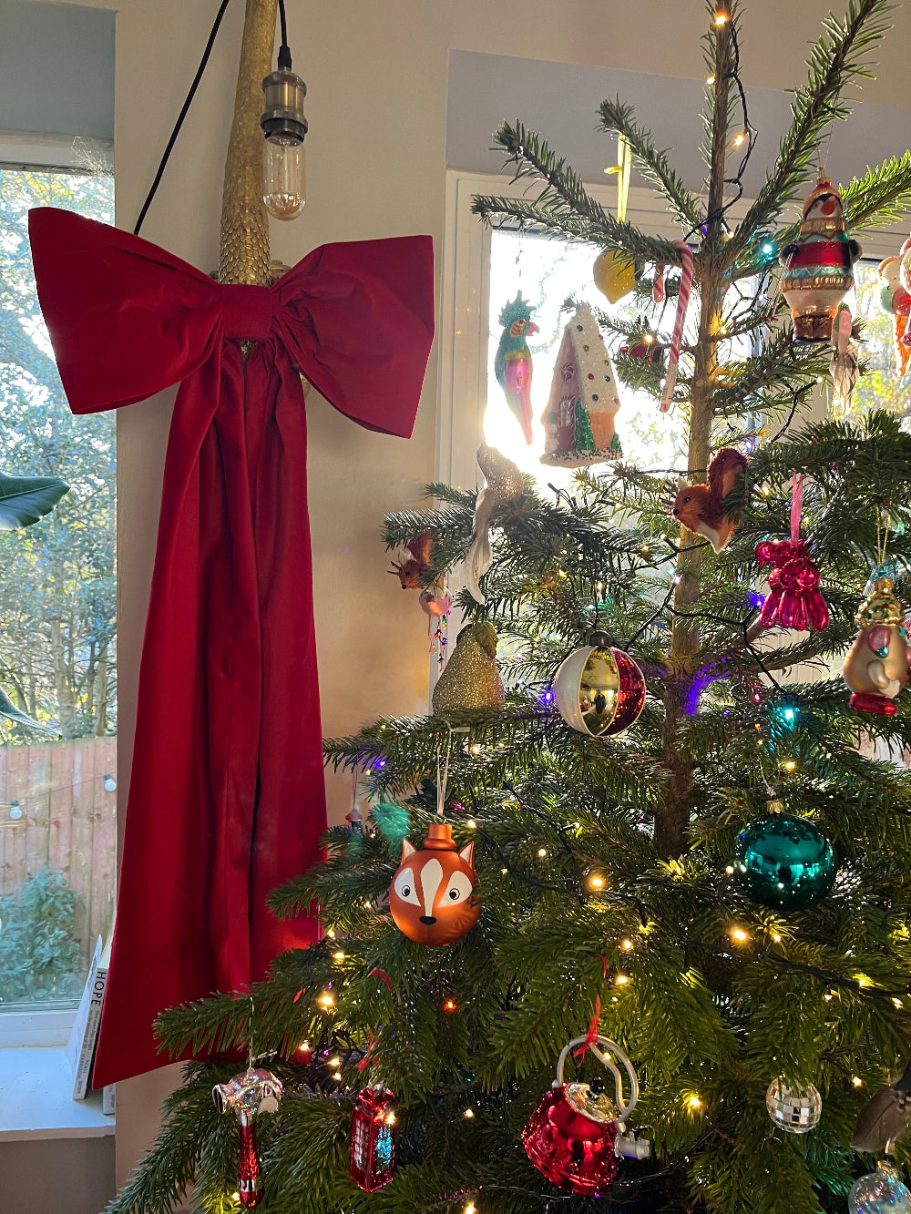 Kika Bespoke oversized red velvet Christmas bow displayed on an interior wall